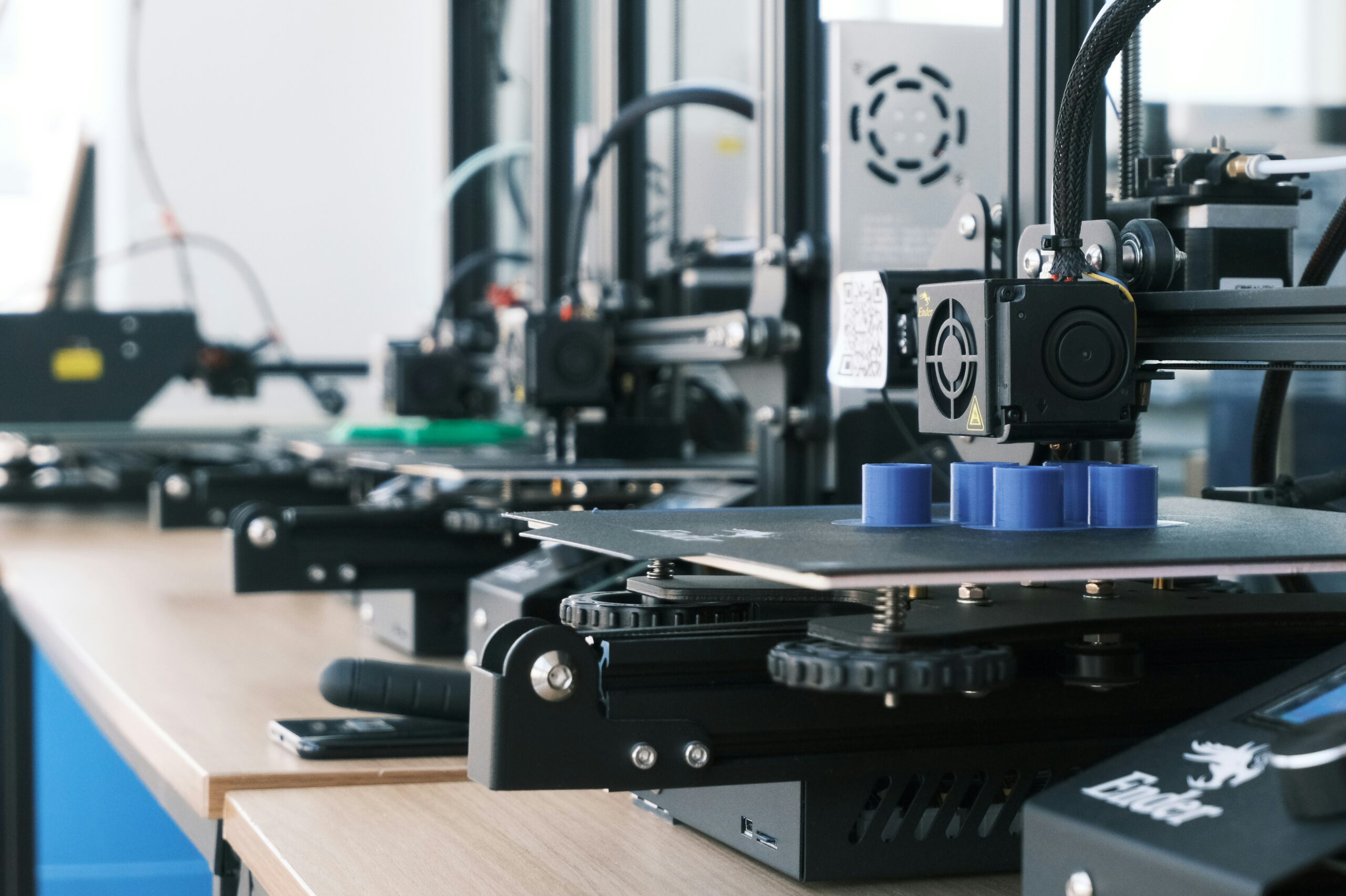 A row of 3D printers producing small batch parts